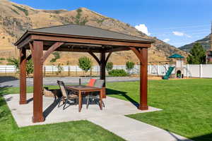 View of patio / terrace with a gazebo, a mountain view, and a playground