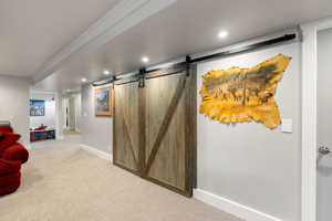 Hall featuring a barn door and carpet flooring