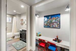 Full bathroom featuring toilet, shower / tub combo, wood-type flooring, and vanity