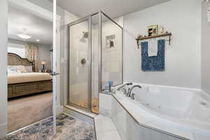 Primary bathroom featuring tile patterned flooring, a textured ceiling, and shower with separate bathtub