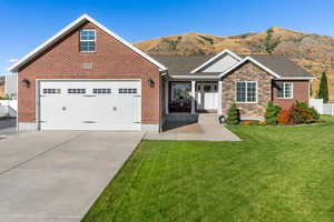 View of front of house featuring a garage, a front lawn, and a mountain view