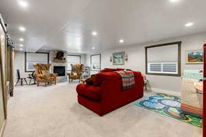 Carpeted living room with a fireplace and a barn door