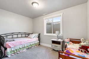 Bedroom with carpet flooring and a textured ceiling