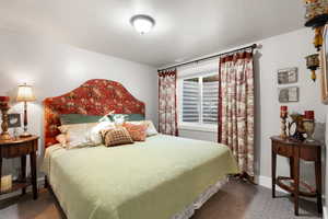 Bedroom featuring a textured ceiling and carpet floors