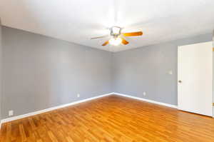 Unfurnished master room with ceiling fan and hardwood / wood-style flooring.