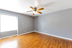 Master bedroom with hardwood / wood-style flooring and ceiling fan.