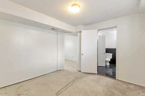 Unfurnished bedroom in basement featuring ensuite bathroom.