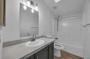 Full bathroom with toilet, hardwood / wood-style flooring, shower / washtub combination, and vanity