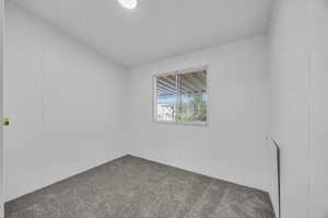 Carpeted spare room featuring a textured ceiling