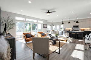 Living room with light hardwood / wood-style flooring, sink, and ceiling fan