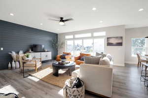 Living room featuring ceiling fan, wood walls, and hardwood / wood-style flooring