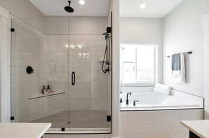 Bathroom featuring vanity and shower with separate bathtub