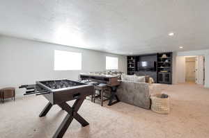 Rec room featuring light carpet and a textured ceiling