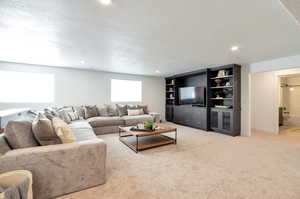 Carpeted living room with a textured ceiling