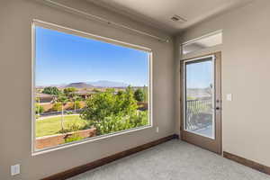 Spare room with a mountain view and carpet