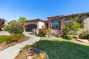 Mediterranean / spanish-style house featuring a garage and a front lawn