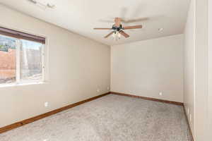 Empty room with ceiling fan and light colored carpet