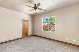 Unfurnished room featuring ceiling fan and light carpet