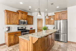 Kitchen with a center island, tasteful backsplash, appliances with stainless steel finishes, and light tile patterned floors