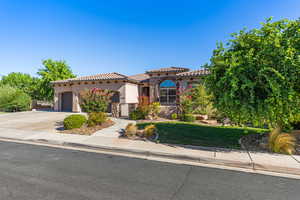 Mediterranean / spanish house featuring a front yard and a garage