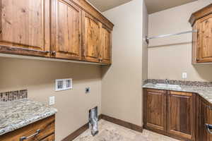 Laundry area featuring sink, washer hookup, cabinets, hookup for an electric dryer, and light tile patterned flooring