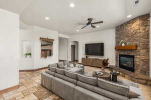 Tiled living room with a fireplace and ceiling fan