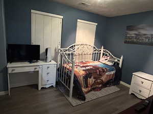 Bedroom with dark hardwood / wood-style floors