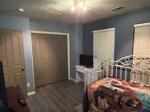 Bedroom featuring a textured ceiling and dark wood-type flooring