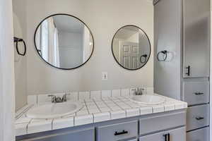 Bathroom featuring dual mirrors and storage