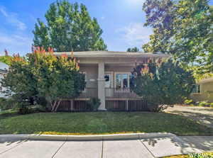 View of front of home with a front yard and covered porch