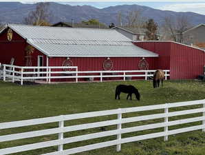 Exterior space featuring a lawn, a mountain view, an outdoor structure, and a rural view