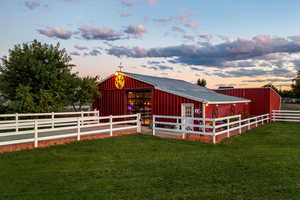 Outdoor structure at dusk featuring a yard