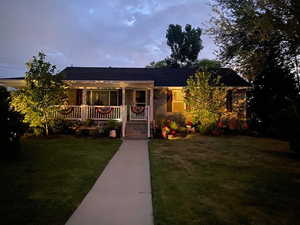 View of front of property with a porch and a front yard