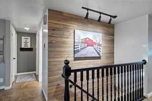 Hallway featuring wooden accent walls