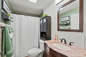 Bathroom featuring a wealth of natural light, toilet, and vanity