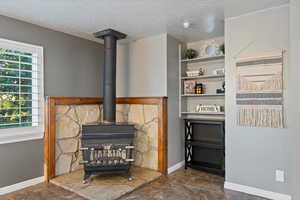 Interior details featuring a wood stove and tile patterned flooring