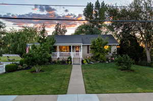 View of front of property featuring a lawn and covered porch