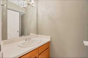 Bathroom with a notable chandelier and vanity