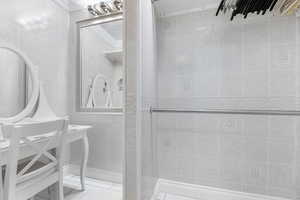 Bathroom featuring tile walls and ornamental molding