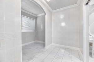 Bedroom featuring crown molding and tile walls