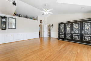 Family room featuring ceiling fan, high vaulted ceiling, and light hardwood / wood-style floors