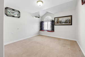 Carpeted bedroom featuring vaulted ceiling