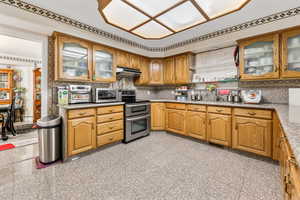 Kitchen with light tile patterned flooring, appliances with stainless steel finishes, sink, and backsplash