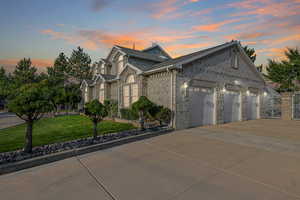 View of front of property with a garage and a yard