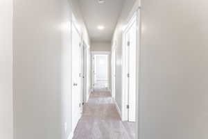 Hall featuring light colored carpet