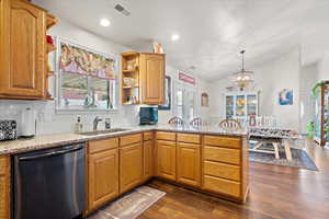 Kitchen with kitchen peninsula, dishwasher, dark hardwood / wood-style flooring, and tasteful backsplash