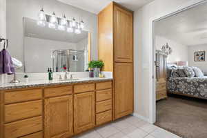 Bathroom featuring a shower with door, vanity, and tile patterned floors