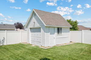 View of outbuilding with a garage and a yard