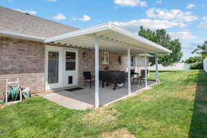 Back of property with a patio area and a yard