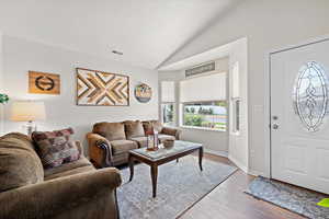 Living room with hardwood / wood-style flooring and lofted ceiling